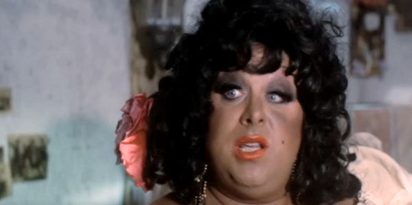 Devine as Rosie Velez, a whole lot of woman with a tattoo on her bottom in Lust in the Dust (1985)