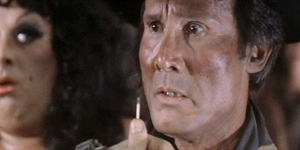 Henry Silva as Bernardo, the fastest gun in Chili Verde until Abel Wood rides into town in Lust in the Dust (1985)