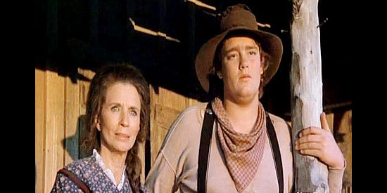 June Carter Cash as Mrs. Pickett and real-life son John Carterr Cash as her son Billy, watching the stage leave their station in Stagecoach (1986)