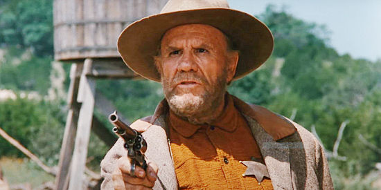 R.G. Armstrong as Reese Scobie, defending the new water tower in Driscoll from the Claver family in Red Headed Stranger (1986)