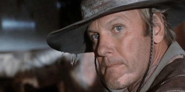 Tab Hunter as Abel Wood, hearing rumors of buried gold somewhere in Chili Verde in Lust in the Dust (1985)