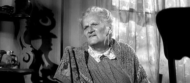 Georgia Simmons as Mrs. Finney, spinning yarns when a young stranger shows up in The Fiend Who Walked the West (1958)