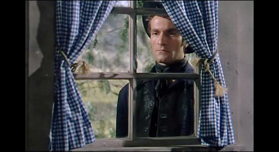 Hugh O'Brian as Hank Purvis, peering in the window of the Murrell home in The Raiders (1952)