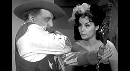 Maria Monay as Lola, warning Windy Wagonwheels (Raymond Hatton) that his trick shots are getting too close for comfort in Flesh and the Spur (1953)