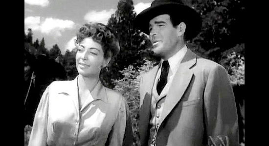 Marie Windsor as Dakota Lil, being shown around the Hole in the Wall gang's hideout by Harve Logan, aka Kid Curry (Rod Cameron) in Dakota Lil (1950)