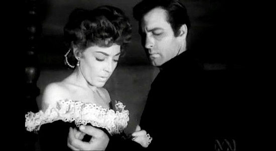 Marie Windsor as Dakota Lil, feeling a handcuff on the wrist of Steve Garrett (George Montgomery) and realizing he's a lawman in Dakota Lil (1950)