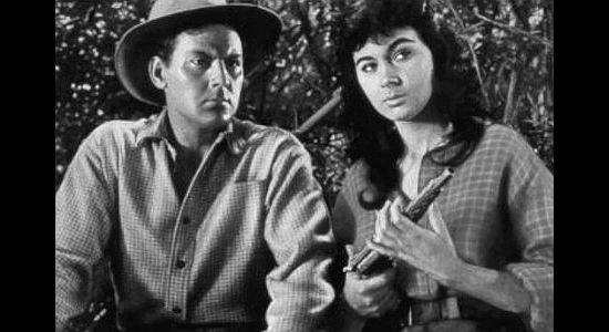 Marla English as Wild Willow, examining the gun Luke Random (John Agar) is seeking the mate to in Flesh and the Spur (1953)