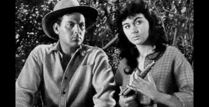 Marla English as Wild Willow, examining the gun Luke Random (John Agar) is seeking the mate to in Flesh and the Spur (1953)