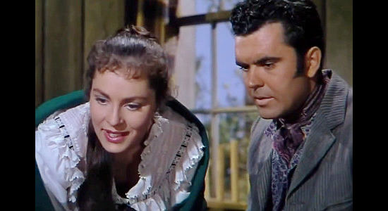 Viveca Lindfors as Elena de Ortega and Richard Marin as her brother Felipe, caring for a wounded Jan Morrell in The Raiders (1952)