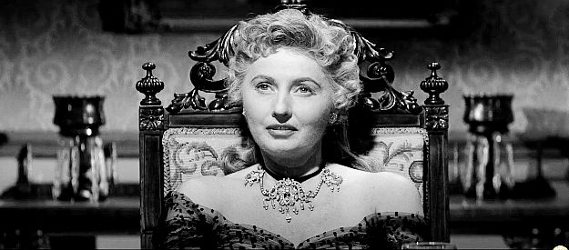 Barbara Stanwyck as Jessica Drummond, sitting at the head of her table of 40 men in Forty Guns (1967)