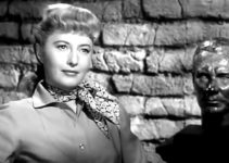 Barbara Stanwyck as Vance Jeffords with a statue of her father when he was young in The Furies (1950)