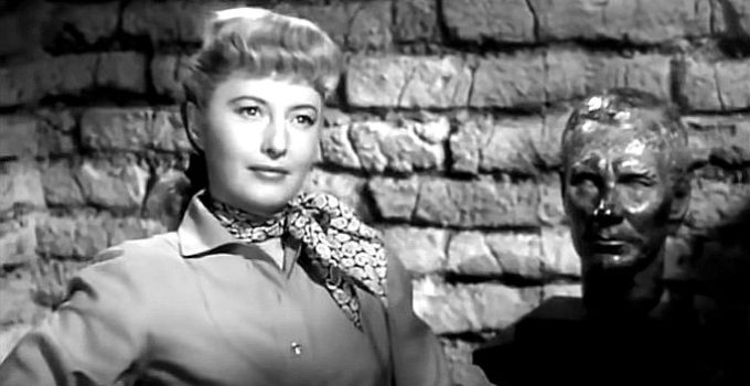 Barbara Stanwyck as Vance Jeffords with a statue of her father when he was young in The Furies (1950)