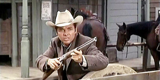 Audie Murphy as Logan Keliher, springing into action when the local bank is being robbed in Bullet for a Badman (1964)
