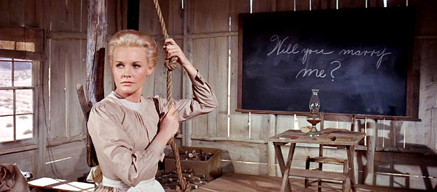 Carroll Baker as Quaker school teacher Deborah Wright, trying to get the Indian children to return and unaware of Archer's chalkboard message in Cheyenne Autumn (1964)