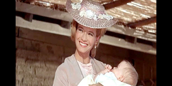 Angie Dickinson as Lisa Denton, visiting with a former saloon girl and her infant in The Last Challenge (1967)