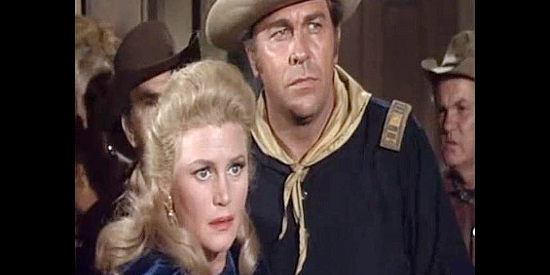Howard Keel as Capt. Tom York, protecting Dakota Lil' McCoy from a saloon mob in Red Tomahawk (1967)