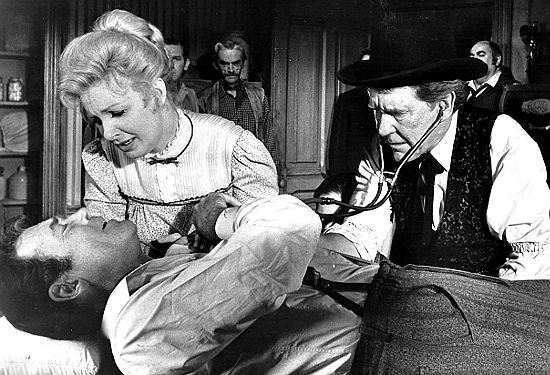Joanne Woodward as Mary checks on her husband Meredith (Henry Fonda) with the help of Doc Scully (Burgess Meredith) in A Big Hand for the Little Lady (1966)