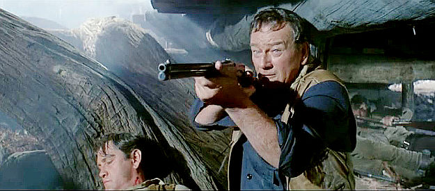 John Wayne as John Elder, locked in a gun battle with some of Morgan Hastings men in The Sons of Katie Elder (1965)