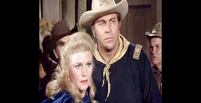 Howard Keel as Capt. Tom York, protecting Dakota Lil' McCoy from a saloon mob in Red Tomahawk (1967)