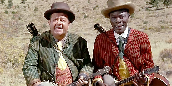 Stubby Kaye and Nat King Cole, delivering one of the musical interludes to narrate the story in Cat Ballou (1965)