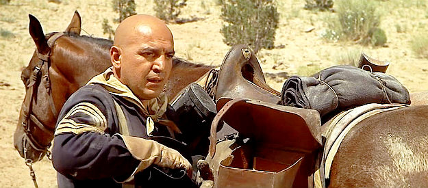 Telly Savalas as Sgt. Tibbs, stashing gold in his saddlebags once the valley is located in MacKenna's Gold (1969)