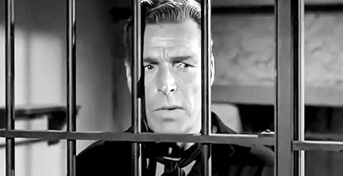 Buster Crabbe as Kip Tanner finds himself on the wrong side of the jail bars in Gunfighters of Abilene (1960)