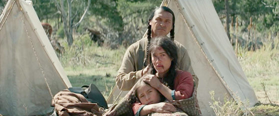Adam Beach as Black Hawk with his wife Elk Woman (Q'orianka Kilcher) and Little Bear (Xavier Horsechief) in Hostiles (2017)