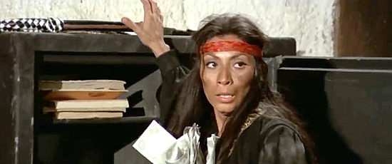 Monica Miguel as the villainess reaches for the loot and her whip in Gunman of 100 Crosses (1971)