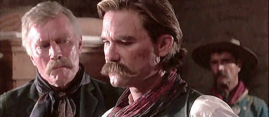Charlton Heston as Henry Hooker, assuring Wyatt an ill Doc Holliday is in good hands in Tombstone (1993)