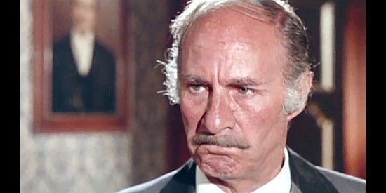 Alfredo Mayor as John Wolley, a leading citizen suspecting his younger wife of cheating in Prey of the Vultures (1972)