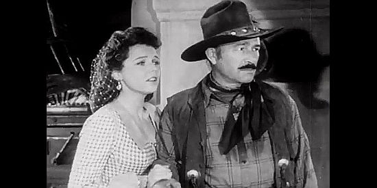 Jane Wyatt as Eleanor Sagar with Robert Armstrong as Malachy, fretting as Bonniwell heads toward a showdown in The Kansan (1943)