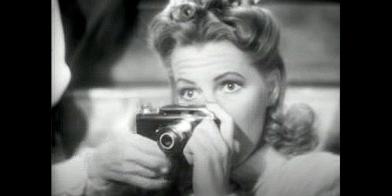 Jean Arthur as Molly J. Truesdale, about to snap a photo that takes her vacation on an unexpected detour in A Lady Takes a Chance (1943)