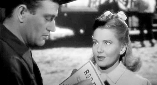 Jean Arthur as Molly J. Truesdale, her vacation out West about to take a turn as she gets an autograph from Kuke Hudkins (John Wayne) in A Lady Takes a Chance (1943)