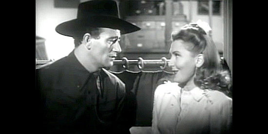 John Wayne as Duke Hudkins and Jean Arthur as Molly J. Truesdale, not realizing she's missed her bus in A Lady Takes a Chance (1943)