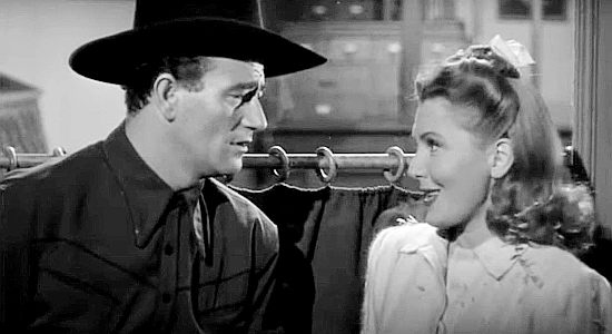 John Wayne as Duke Hudkins, dropping Molly J. Truesdale (Jean Arthur) off at her bus stop in A Lady Takes a Chance (1943)