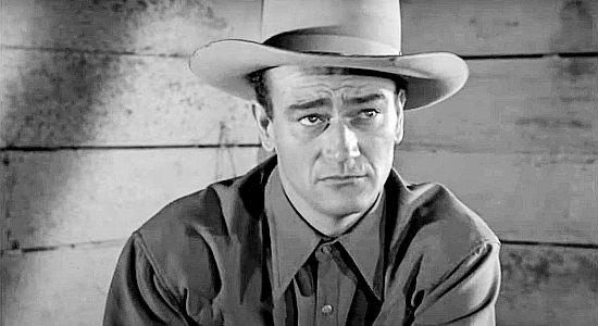 John Wayne as rodeo rider Duke Hudkins, concerned about his sick horse Sammy in A Lady Takes a Chance (1943)