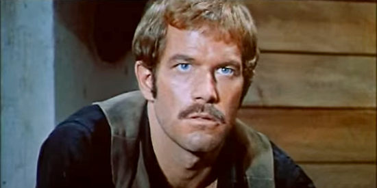 Richard Harrison as Robert Walton (aka Wayne Sonnier) perks up when he hears a name from his past in Stagecoach of the Condemned (1970)
