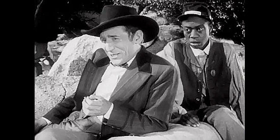 Victor Jory as Jeff Barat, trying a ploy on his brother's allies while accompanied by Willie Best as Bones in The Kansan (1943)