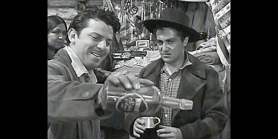 John Carroll as Pierre pours out the whiskey Clairou (Sheldon Leonard) is trading to the Indians in Pierre of the Plains (1942)