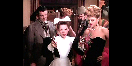 Judy Garland as Susan Bradley, armed with two six guns, goes searching for stolen steaks in The Harvey Girls (1946)