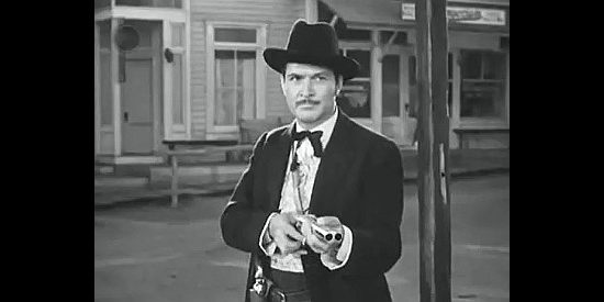 Kent Taylor as Doc Holliday, wielding his shotgun at the O.K. Corral in Tombstone, the Town Too Tough to Die (1942)
