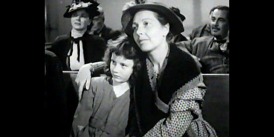 Marlene Mains as Annie Logan, the ill child Dora helps care for with her mother (Frances Morris) in The Woman of the Town (1943)