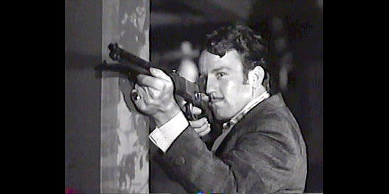 Steve Brodie as Logan Maury, firing a shot at someone who betrays him in Trail Street (1947)