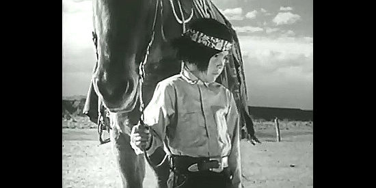 Francis Kee Teller as Son of the Hunter, holding his family's horse during a visit to the trading post in Navajo (1952)
