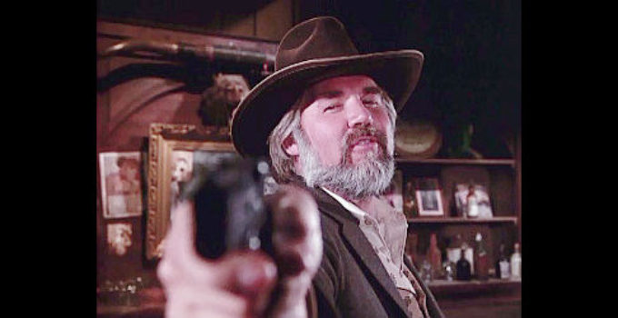 Kenny Rogers as Brady Hawkes with an adversary under his gun in The Gambler (1980)