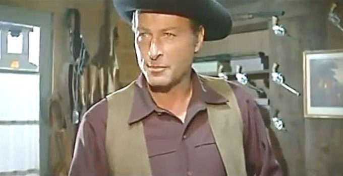 Lex Baker as Sam Dobie, making a business proposition to gunshop owner Cathy Carmichael in Who Killed Johnny R. (1966)