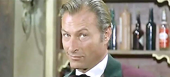 Lex Barker as Sam Dobie, content to sell guns and let someone else do the fancy shooting in Who Killed Johnny R? (1966)