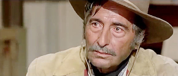 Jose Nieto as Sheriff Mortimer, questioning Roy Greenfield, a newcomer to town in Dead Men Ride (1971)