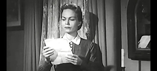 Kristine Miller as Kathryn Bonham, reading a letter left by her son as he rides off seeking revenge in The Persuader (1957)