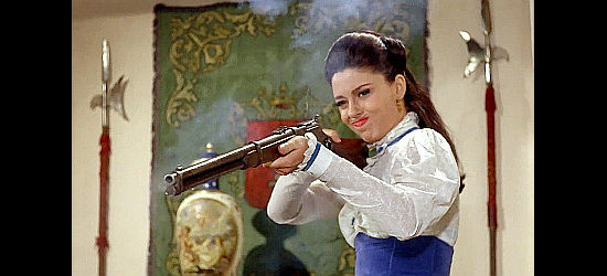 Monica Randall as Carmencita Brenton demonstrating how forgiving she's feeling as smoke billows from her gun in Fistful of Knuckles (1965)